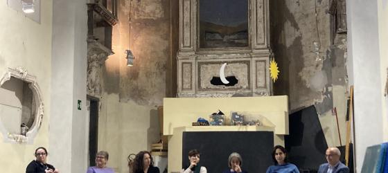 Gruppo di persone, uomini e donne, in semicerchio per momento di confronto 