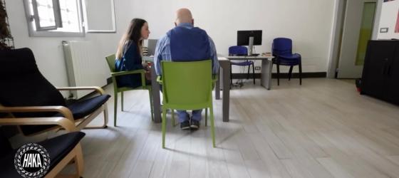 vista aula universitario in carcere, sullo sfondo una tutor e un detenuto seduti alla scrivania per studiare