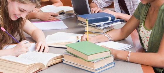 gruppo studenti al tavolo tra i libri 