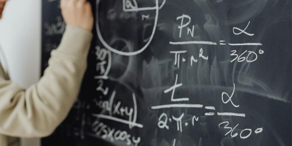 primo piano una lavagna di ardesia con scritte formule matematiche
